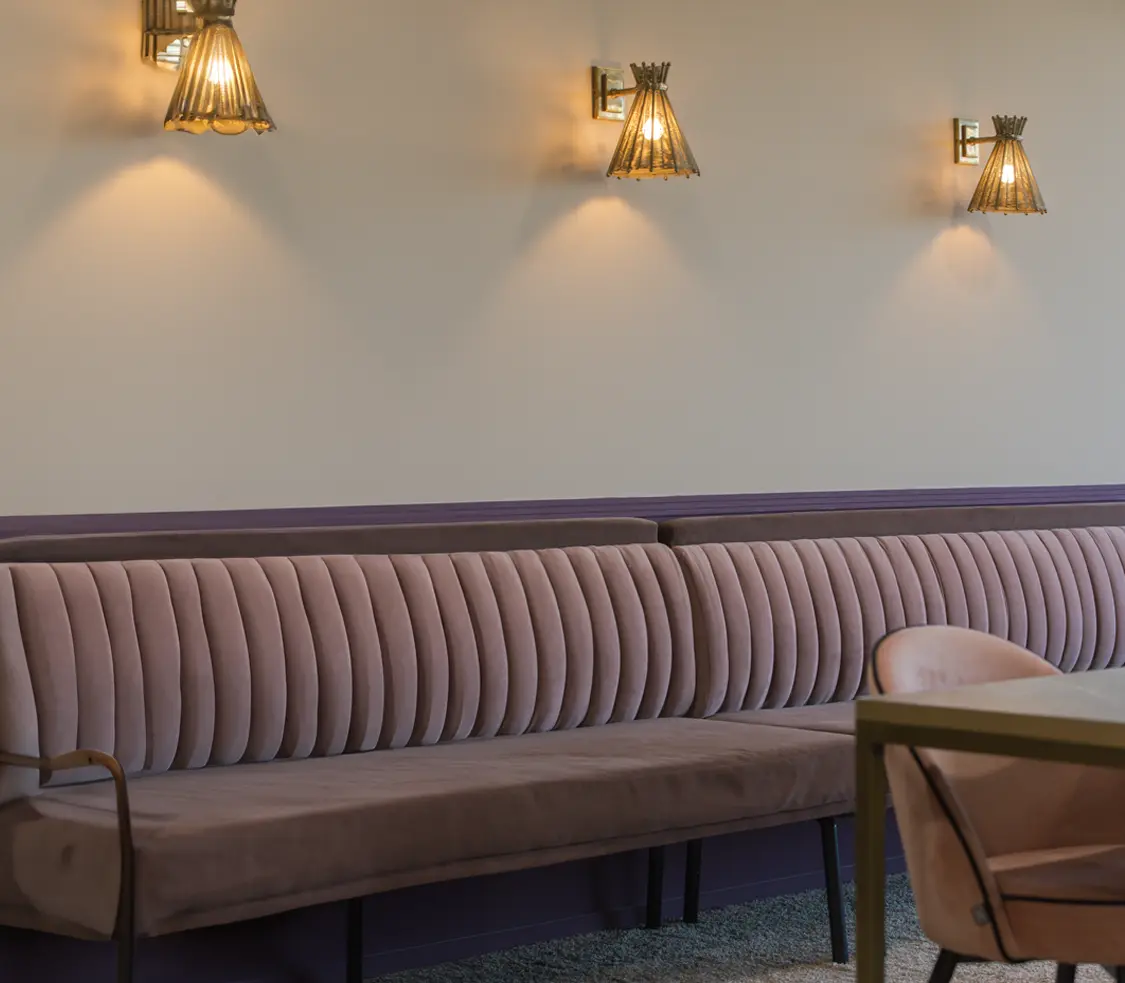 Canapé en velours rose poudrée avec trois appliques au mur